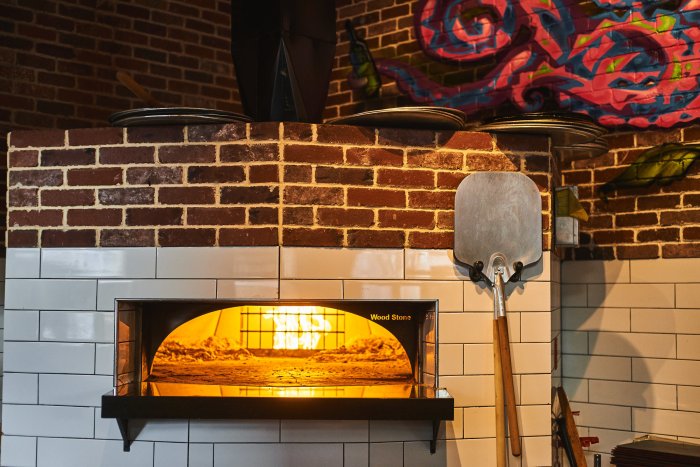 Three students have a circular pizza